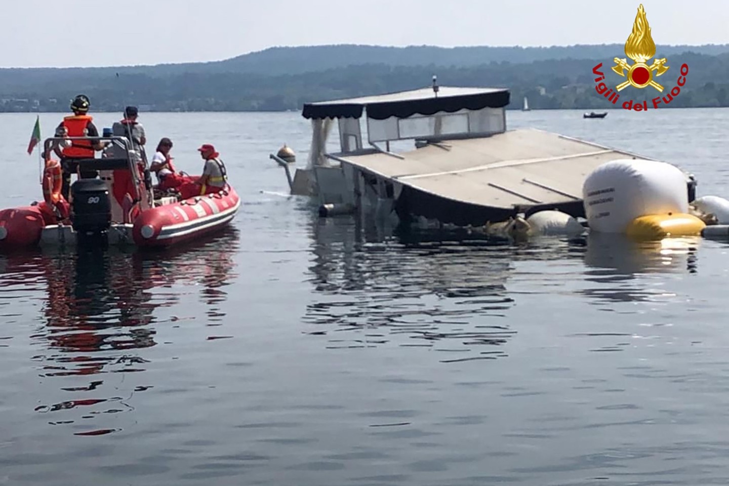 Einsatzkräfte der Feuerwehr holen das gesunkene Boot auf dem Lago Maggiore mit Ballons an die Oberfläche.