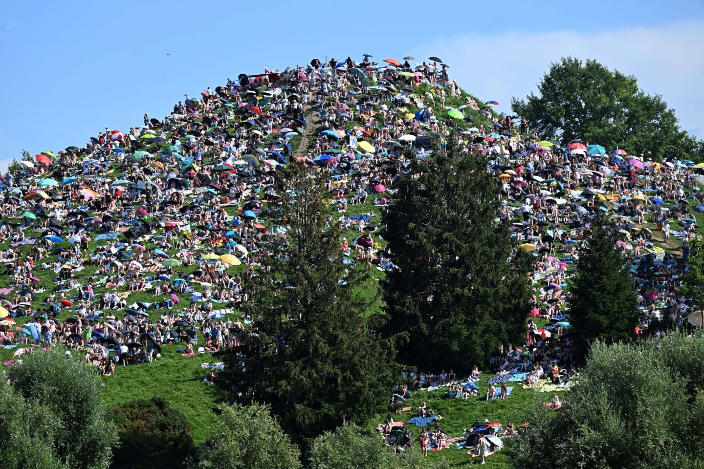 Viele Fans setzten sich auf den Olympiaberg im Münchner Olympiapark, um dem Konzert von Taylor Swift zu lauschen.